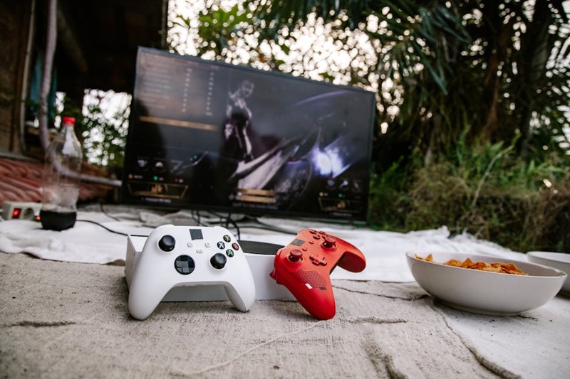 Un joueur souriant utilise une manette sur une tablette, affichant un jeu vidéo en streaming fluide.