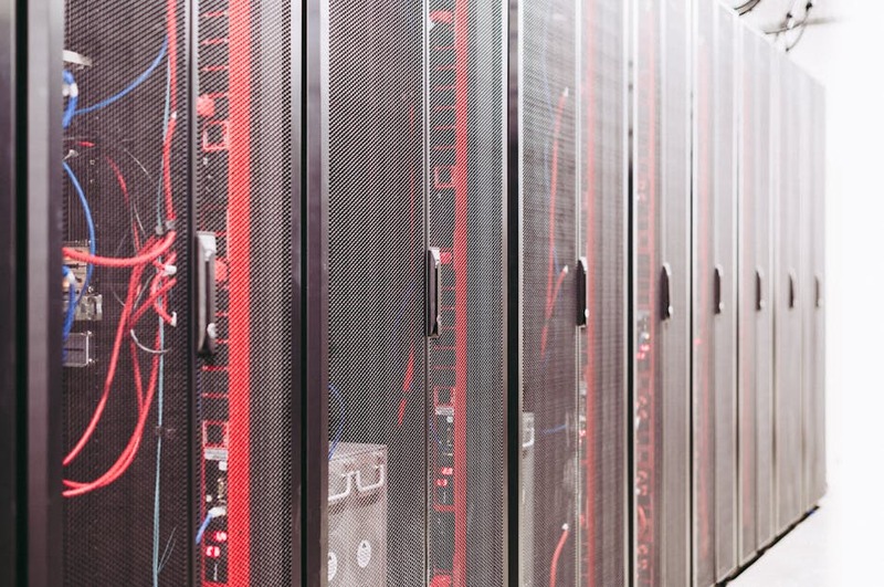 Racks de serveurs informatiques dans un centre de données moderne avec des lumières bleues.