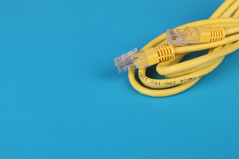 Un câble Ethernet branché à un routeur et un ordinateur portable.