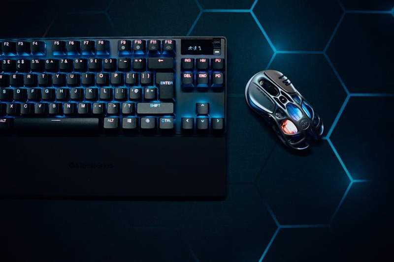 Souris gaming SteelSeries Aerox 3 Wireless noire sur un tapis de souris RGB