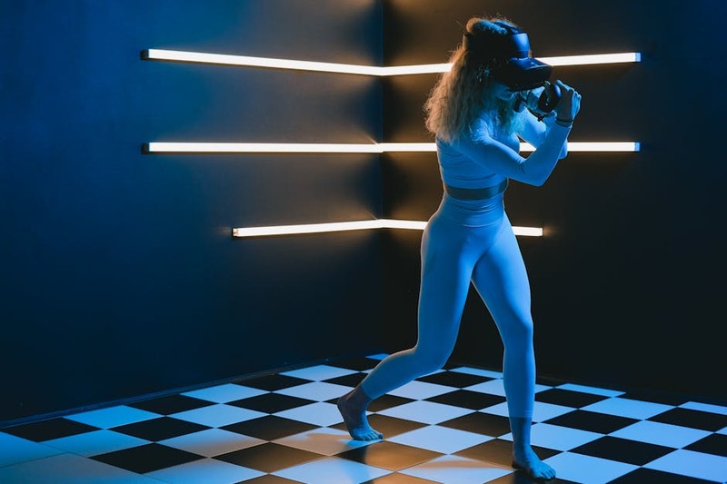 Une personne jouant à un jeu vidéo futuriste avec des lunettes AR dans un salon moderne.