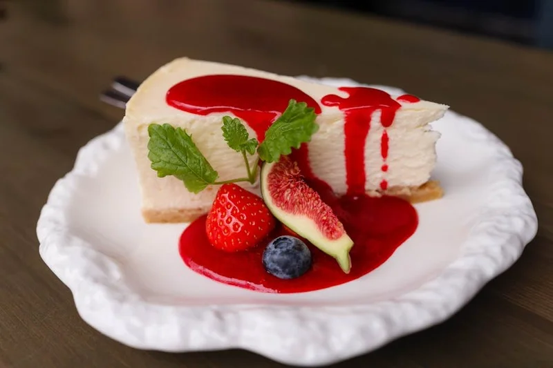 Part de cheesecake New-Yorkais avec coulis de fruits rouges