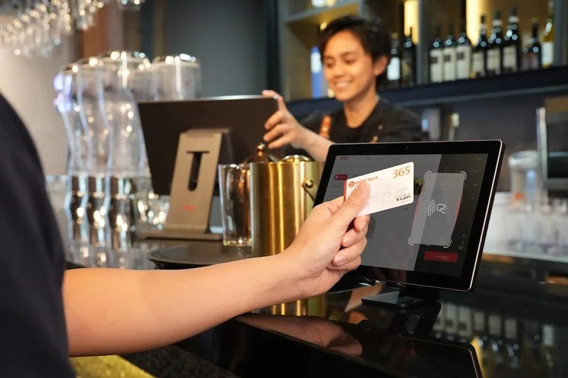 Une personne montrant une carte de fidélité au comptoir d'un restaurant