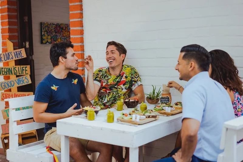 Un groupe diversifié de personnes dégustant un repas dans un restaurant lumineux et moderne respectueux de l'environnement