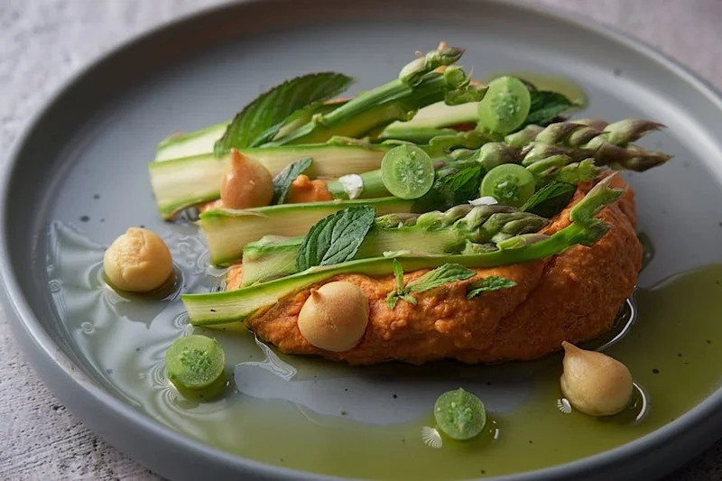 Un plat végétalien gastronomique magnifiquement dressé avec des légumes et herbes vibrants
