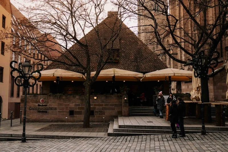 Une personne marchant vers l'entrée d'un charmant restaurant dans une rue pavée