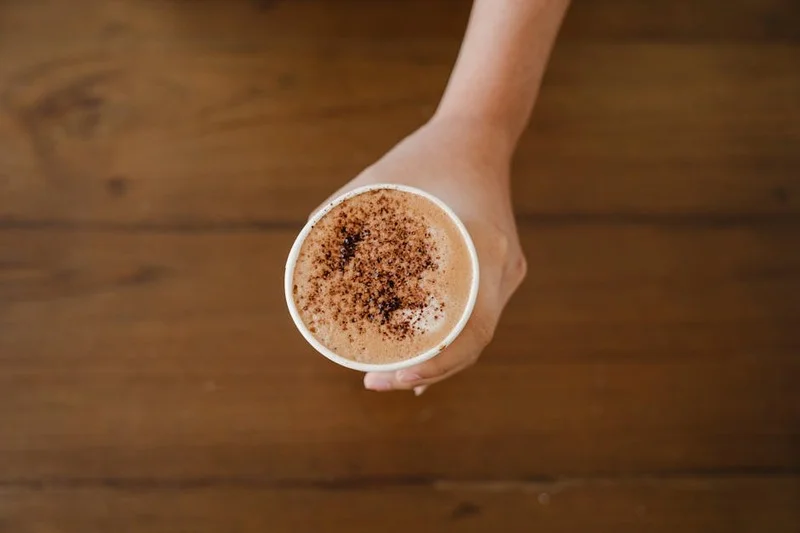 Délicieux cappuccino avec une épaisse couche de mousse et de la poudre de cacao