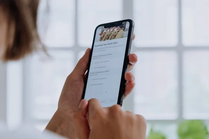 Une personne interagissant avec une application mobile affichant des options de restaurants adaptés aux allergies
