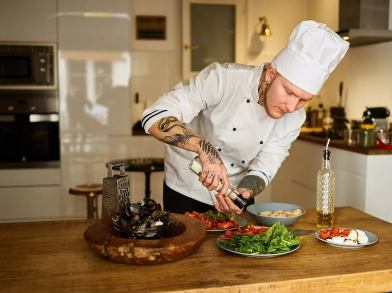 Un chef préparant des ingrédients frais et locaux dans une cuisine moderne et décontractée
