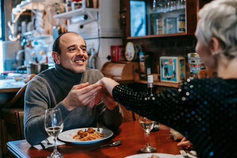 Un couple savourant un repas au restaurant, souriant et détendu