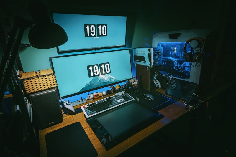 Un bureau de jeu moderne avec un moniteur affichant un jeu, et un PC Linux à côté