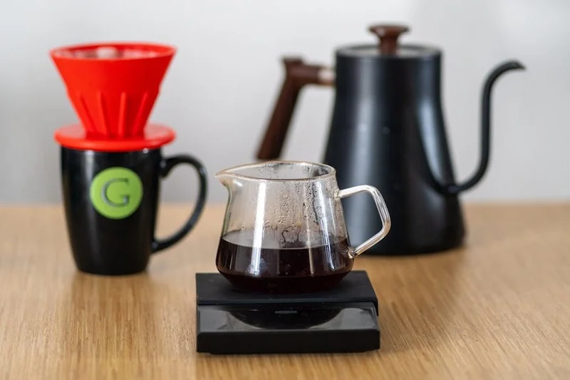Divers dispositifs de préparation manuelle comme Chemex, V60 et Aeropress sur une table en bois