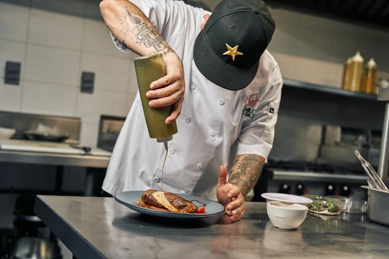 Bras robotique dressant délicatement un plat gastronomique dans une cuisine moderne