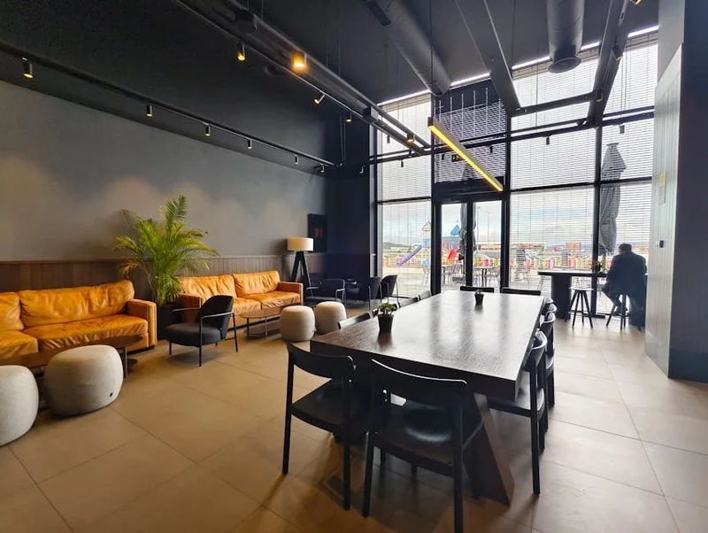 Coffee shop de style loft industriel avec de grandes fenêtres et des sièges modernes, Bruxelles