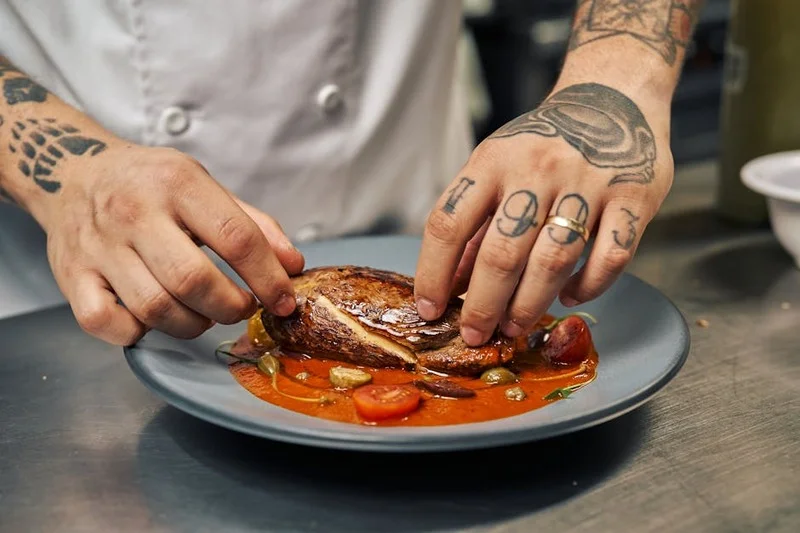 Un chef présentant un plat gastronomique superbement dressé